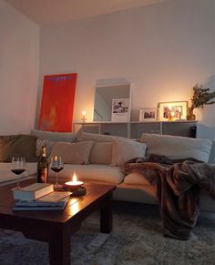 a living room filled with furniture and a wine glass on top of a coffee table