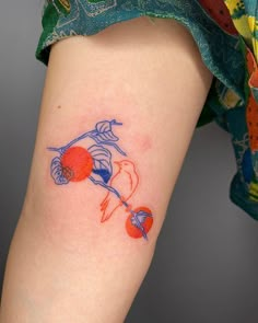 a woman's leg with a tattoo on it that has an orange and blue design