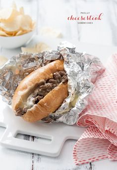 a close up of a sandwich on tin foil with cheese and meat in the middle