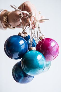 a person is holding some ornaments in their hand and they are hanging from the strings