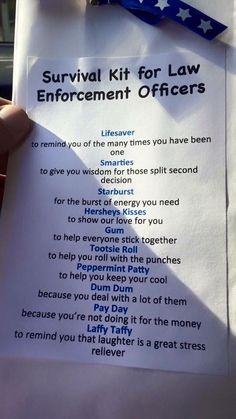 a person holding up a paper sign with the words survival kit for law enforcement officers