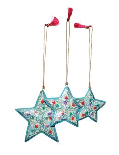 two blue stars hanging from strings with red tassels on each one and the other side