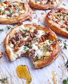 several small pizzas with different toppings sitting on top of a sheet of paper