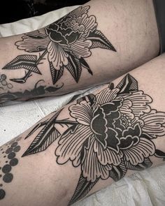 two people with tattoos on their legs, one has a flower and the other has leaves