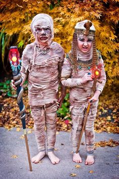 two people dressed in costumes holding skis and poles