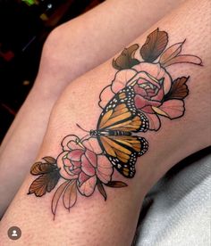 a woman's thigh with a butterfly and flowers on it