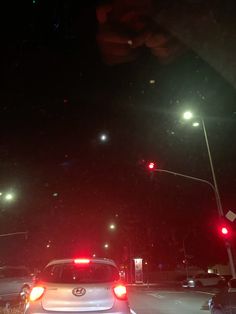 a car stopped at a red light in the middle of the night with it's brake lights on