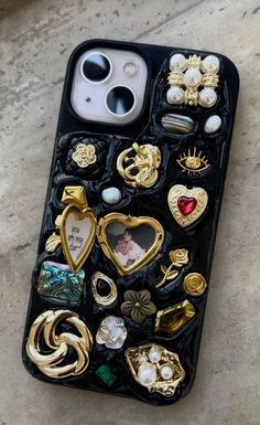 an iphone case with lots of different buttons and charms on it's back cover