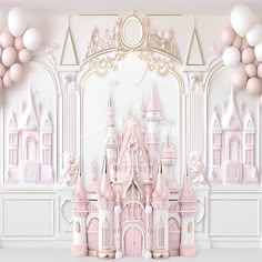 a pink castle is surrounded by balloons in front of a white wall with gold trim