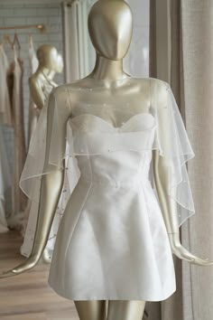 a mannequin wearing a white wedding dress and veil