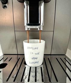 a coffee cup that has been placed on the espresso machine for someone to drink