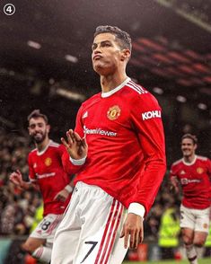 the soccer player is wearing red and white uniform with his hands together as he stands in front of other players