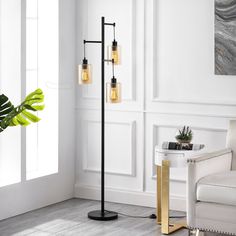 a living room with a white chair and a black floor lamp in the corner next to a potted plant