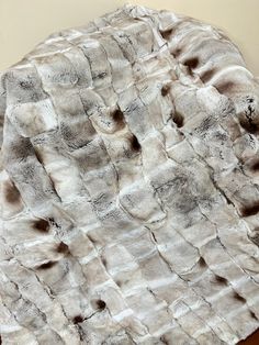 a white and black fur blanket on top of a wooden table