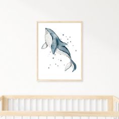 a baby's room with a white crib and a blue whale print on the wall