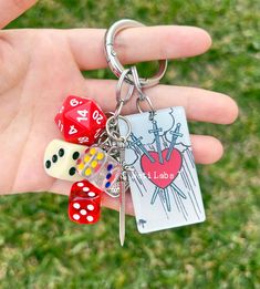 a hand holding a key chain with dices on it