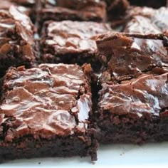 chocolate brownies are sitting on a white plate and ready to be cut into squares