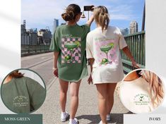 two women wearing matching tshirts walking down the street with their backs to each other