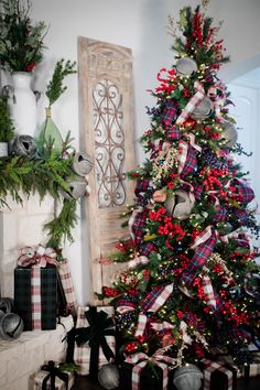 a decorated christmas tree in front of a fireplace