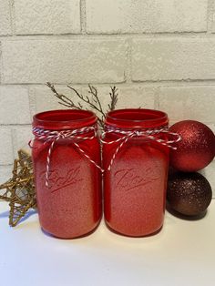 three red mason jars sitting next to each other on top of a white countertop