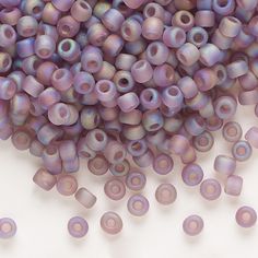 purple beads are scattered on a white surface