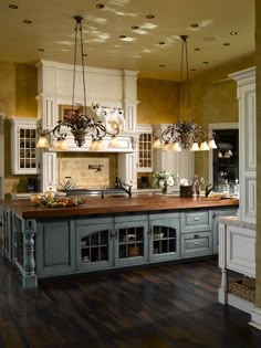 an image of a kitchen with white cabinets and wood flooring on the bottom level