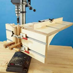 a machine that is on top of a wooden table next to a piece of wood