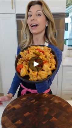 a woman holding a pan full of food