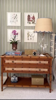 a bedroom with striped walls and pictures on the wall, including a table with flowers