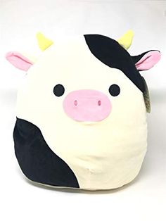 a black and white cow pillow sitting on top of a table