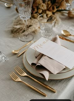 a table set with place settings, silverware and napkins for an elegant dinner