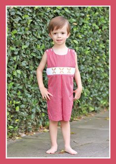 Prepare for baseball season in style with our Baseball Smocked Red Plaid Jon Jon. This charming red gingham plaid bubble features smocked bats and baseballs, creating a playful and sporty look. The thoughtful design includes convenient shoulder buttons and snaps in the stride, ensuring easy dressing and undressing for your child.childrens clothing, baseball season, baseball smocking, gingham outfit, red gingham, baseball bat and ball, bubble, jon jon, short set, dress, ruffles, little girls baseball outfit, little boys baseball outfit, mlb, mlb game, mlb gameday ootd, spring training outfit, play ball, kids mlb game outfit, red baseball teams, southern sunshine, kids playwear, classic whimsy, smocked auction, Dallas Texas, online shopping, kids clothing collection, summer baseball