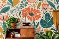 a room with colorful wallpaper and potted plants on the shelf next to it