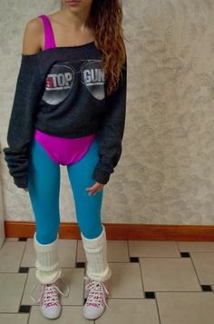 a young woman wearing leggings and an off the shoulder top standing in front of a tiled floor