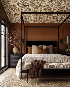 a canopy bed in a bedroom with floral wallpaper on the ceiling and carpeted floor