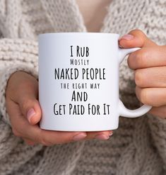 a woman is holding a coffee mug that says i rub mostly naked people the right way and get paid for it