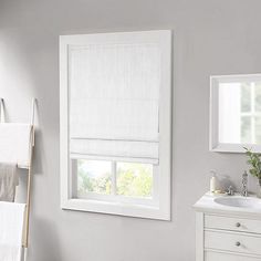 a bathroom with a sink, window and towel rack