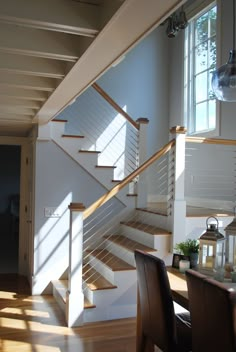 the stairs in this house are made of wood and have white railings that lead up to the second floor