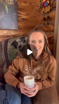 a woman sitting on a couch holding a cup of coffee