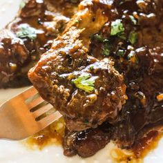 a close up of food on a plate with a fork in it and another piece of meat