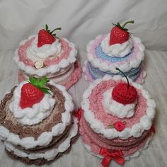 several crocheted cakes with strawberries on top