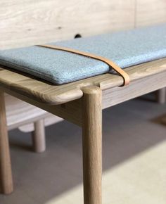 a wooden bench with a blue cushion on it