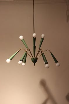 a green and white chandelier hanging from a ceiling in a room with no one around it