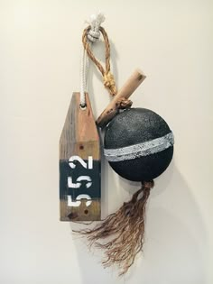 a wall hanging with an old ball, baseball bat and wooden block on it's side