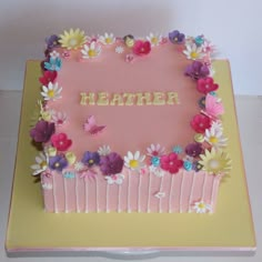 a pink cake with flowers and butterflies on it's side that says, mother