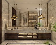 a bathroom with marble counter tops and gold lights hanging from the ceiling, along with a large mirror on the wall