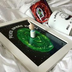 a painting on a table next to a coffee mug and an object in the shape of a spaceship