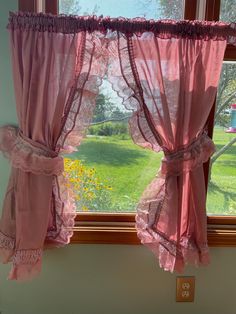 the curtains are hanging on the window sill in the room that is decorated with pink lace