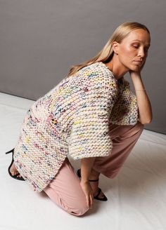 a woman kneeling on the ground with her hand to her face