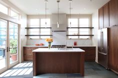 a large kitchen with wooden cabinets and white counter tops